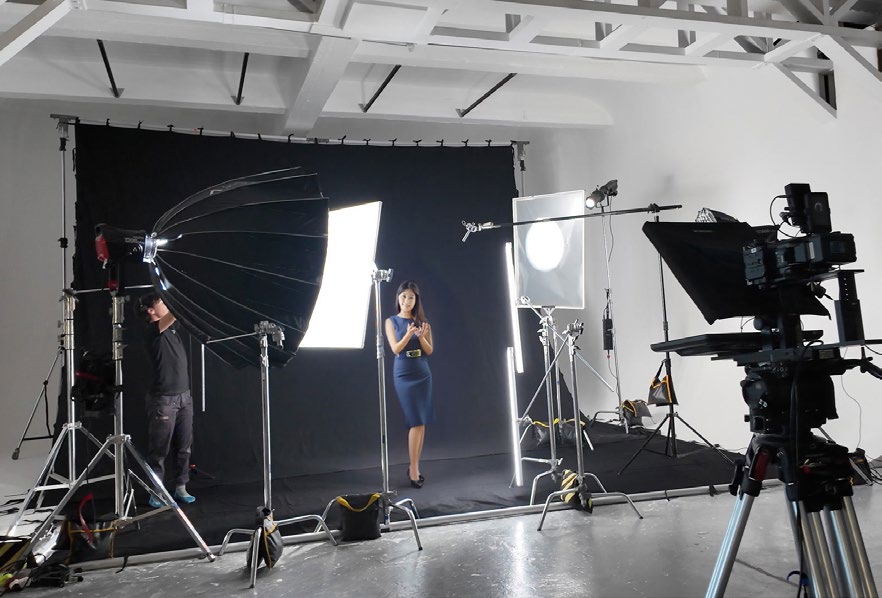 A presenter on a white cyclorama under studio lights during performance capture for a conversational AI avatar